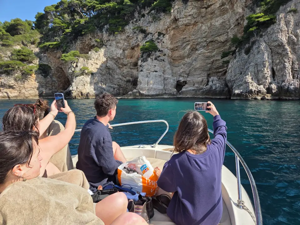 Privatni brod uz hridi i tirkizno more na ruti najma broda Dubrovnik iz Marine Frape Lapad