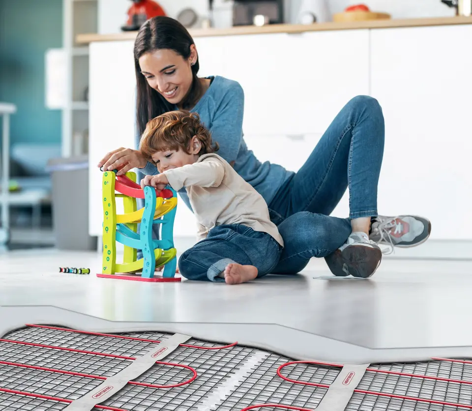 Young beautiful mother playing on the floor with her son in livi